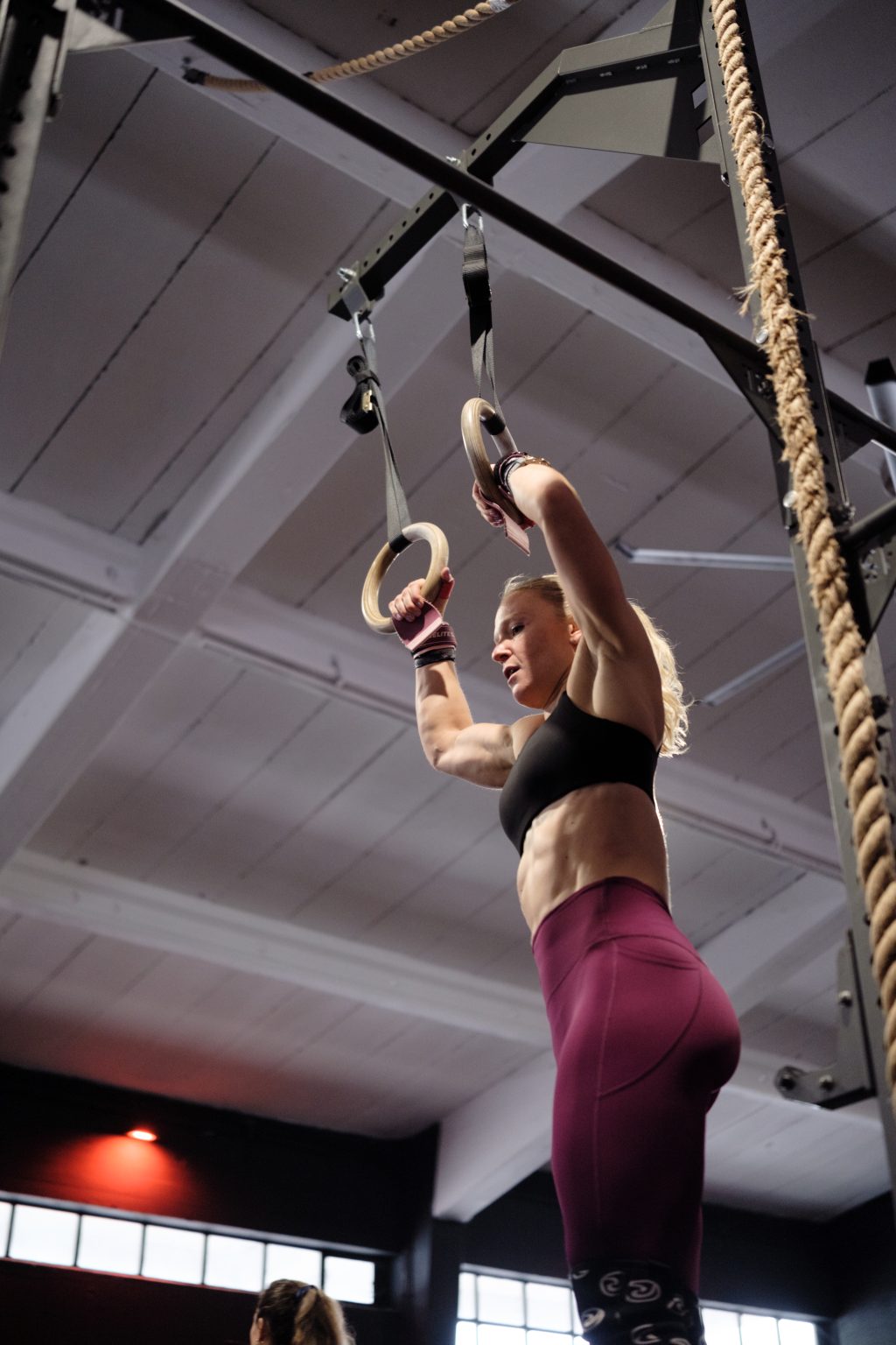 Athletin beim Muscle-Up an den Ringen