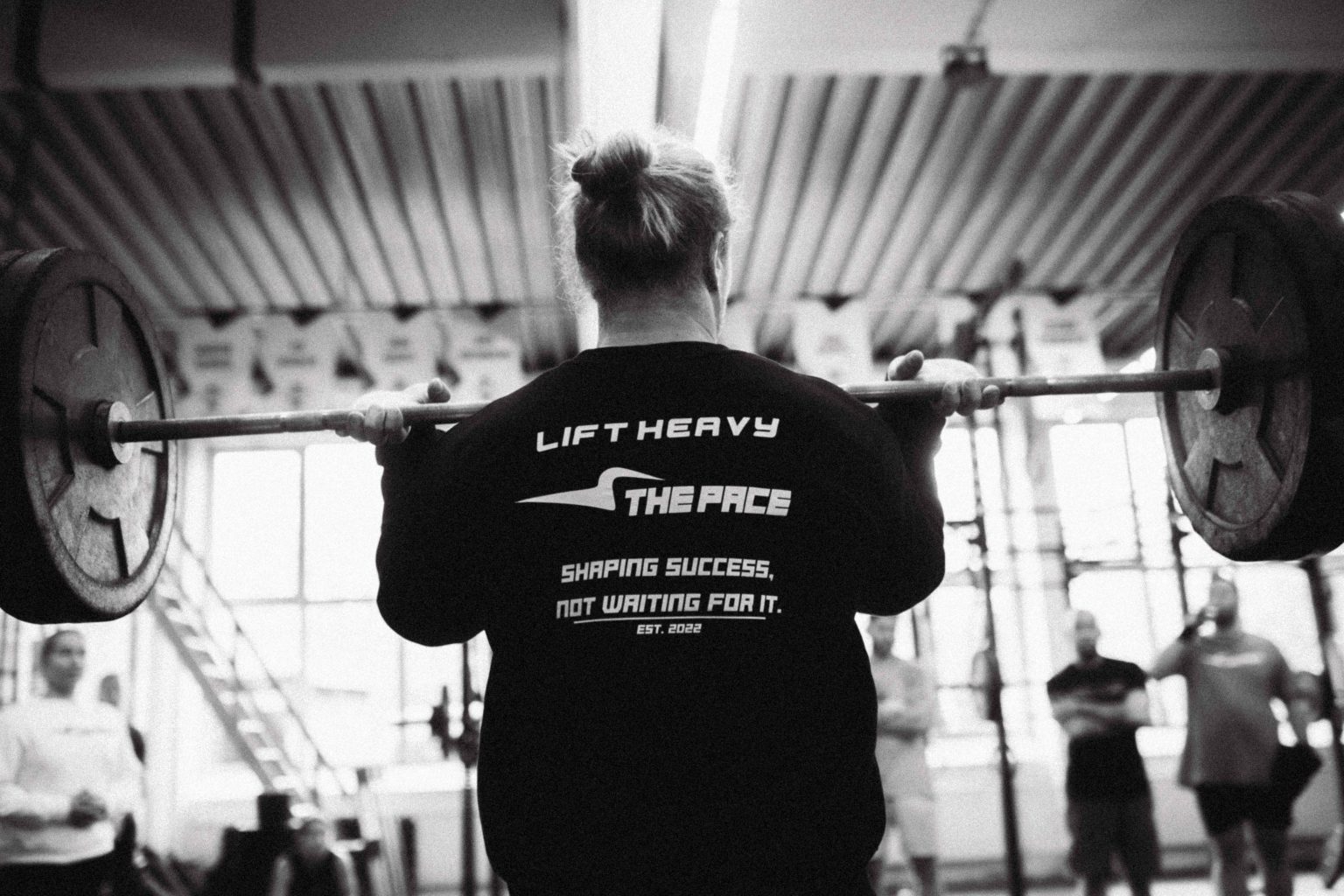 Athletin im The Pace Shirt beim Training mit der Langhantel
